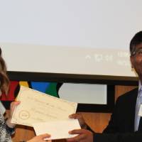 Dr. Molla and the winner of the people's choice poster award shaking hands, smiling